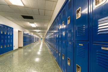 Empty school hallway with blue student lockers
