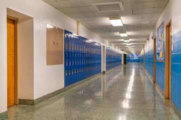 Empty school hallway with blue student lockers
