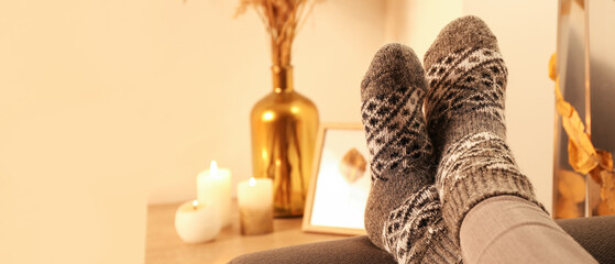 Woman in warm socks relaxing at home, closeup