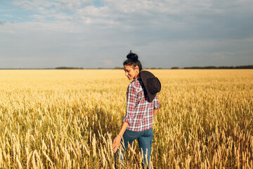 Naklejka na ściany i meble Woman american farmer wearing cowboy hat, plaid shirt and jeans at wheat field.