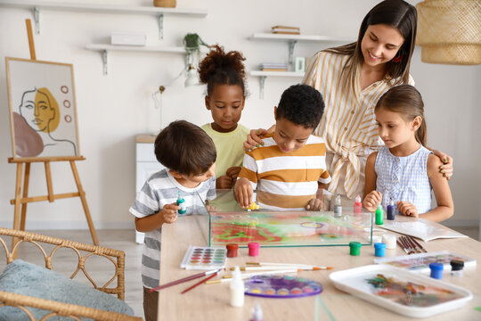 Little children with teacher during master class in Ebru painting at workshop