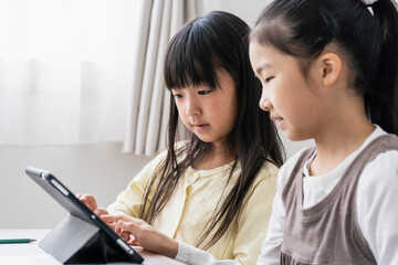 タブレットPCを見る日本人小学生の女の子