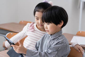 教室でタブレットPCを見る日本人小学生