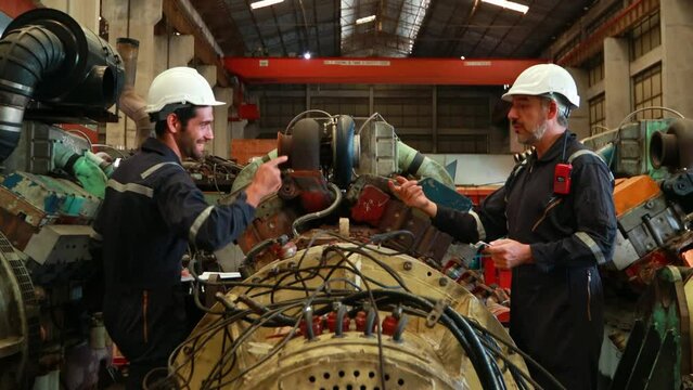 Engineer in the process of inspecting train engines Keep the machine ready for use in the train station. Engineers wear safety clothing and helmets to work safely as standard.
