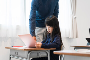 ノートパソコンを使った授業をうける日本人小学生の女の子