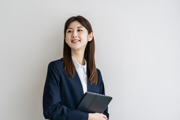 タブレットPCを持つスーツ姿の日本人女性