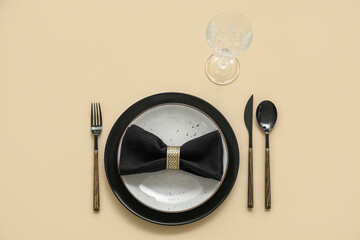 Obraz na płótnie Canvas Elegant table setting with black napkin on beige background