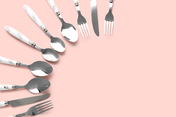 Silver cutlery on pink background
