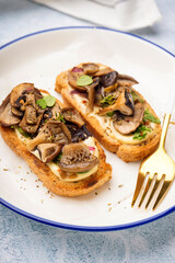 Plate of tasty toasts with cream cheese and mushrooms on light background, closeup