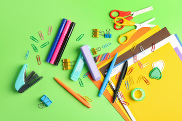 Set of different stationery on green background