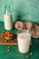 Glass of almond milk on color background