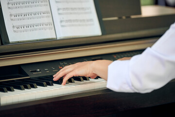 Woman plays electric piano at outdoor music performance, close up view to pianist nimble hands. Female plays classical music on synthesizer, dexterous fingers press synthesizer keys, virtuoso playing © TRAVELARIUM