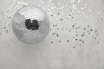 Disco ball with confetti on grey background