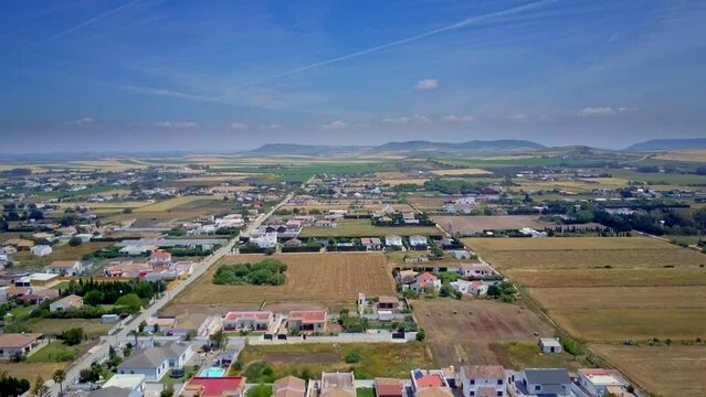 drone timelapse over Palmar beach in Cadiz Spain where the drone glides from the small country houses from the beach and shows us the mountains around and the sunny cloudy day