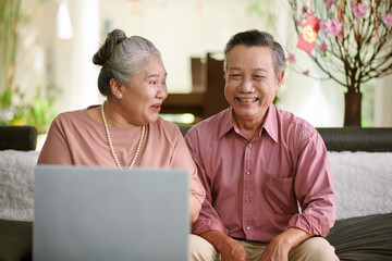 Happy smiling senior couple video calling family members on Lunar New Year