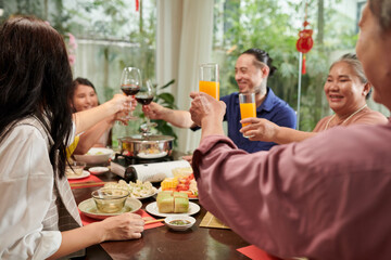 Family toasting at dinner table when celebrating Tet together