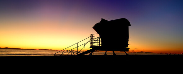 Sandman: Sunset near a lifeguard tower in Huntington Beach, California