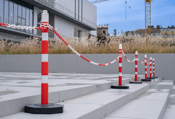 Bright orange traffic cones and plastic chain or car barriers.