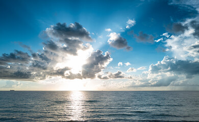 Obraz premium Sea sunset with cloudy sky and sun through the clouds over. Clouds Ocean and sky background, seascape.