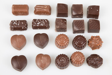 fine dark and milk chocolate in different shapes on white table pralines candies in flat top view