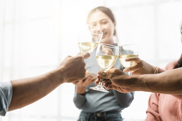 Group of happy colleagues having fun at a new year celebration or business success. Coworkers with diverse people at the office party
