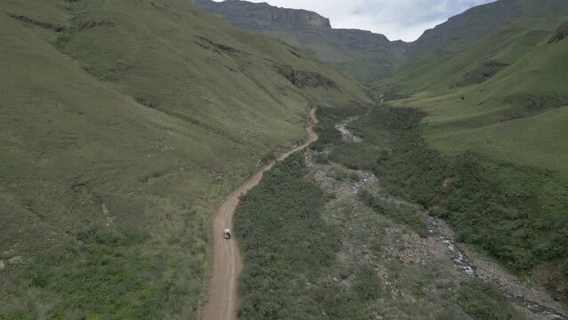 Dramatic aerial vista as SUV drives up Sani Pass valley, South Africa