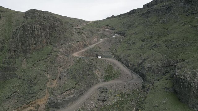 Famous Sani Pass dirt road, switchback vehicles near Lesotho plateau