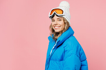 Sise view happy snowboarder woman wear blue suit goggles mask hat ski padded jacket spend extreme weekend look camera isolated on plain pastel pink background. Winter sport hobby trip relax concept.