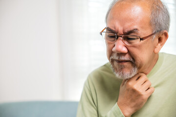 Asian old man painful in the sore throat, retirement senior man feeling pain use hands holding...