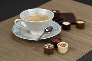 Chocolate temptation with a variety of delicious chocolate candies and vintage cup of coffee