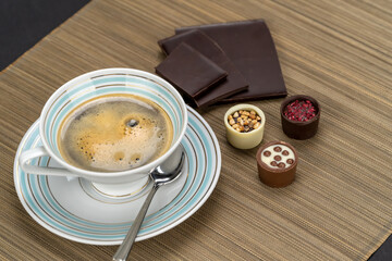 Chocolate temptation with a variety of delicious chocolate candies and vintage cup of coffee