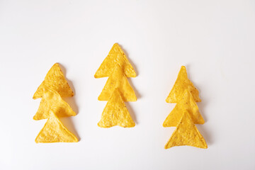 Mexican corn chips nachos laid out in the form of a Christmas tree on a white background