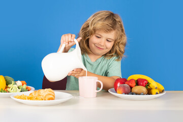 Healthy child pours milk from jug. Child drink dairy milk.