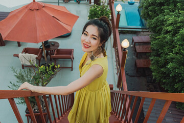 beautiful asain woman at the rooftop of the hotel looking at the camera