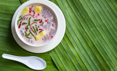 Thai rice flour dessert, Thai dessert -cantaloupe jelly mixed fruit with coconut milk and syrup sweets dessert on bowl, Asian food