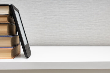 e-book lies on a stack of paper books.