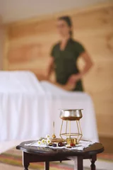 Wall murals Massage parlor Table with hot oil for tuna massage with masseuse and stretcher with out-of-focus background.