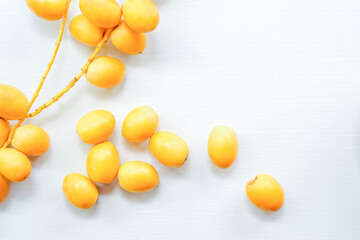 Fresh yellow dates on a white table. Top view.