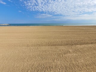 Wonderful empty and wide open beachfront on a sunny day with some clouds. space for text.