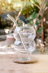 Glass cups and straws  against a blurred background.