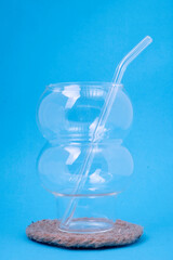 Fototapeta na wymiar Glass cups and straws on a blue background