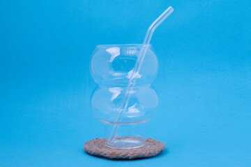 Fototapeta na wymiar Glass cups and straws on a blue background