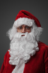 Portrait of santa claus with beard and red costume against grey background.