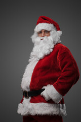Fototapeta na wymiar Studio shot of cheerful elderly santa dressed in red winter costume.