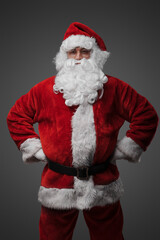 Portrait of isolated on grey santa dressed in red costume staring at camera.