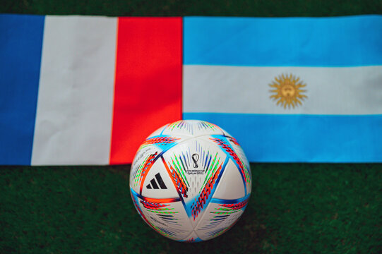 QATAR, DOHA, DECEMBER 2. 2022: FINAL Argentina - France, Official ball of Fifa world cup Qatar 2022 on green grass. Soccer stadium in background. Handmade national flags
