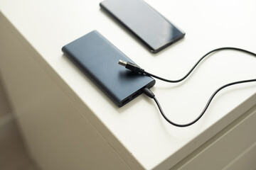 Smartphone charging with power bank on wood board