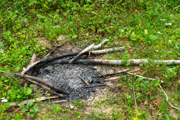 Obraz premium Extinguished bonfire on a meadow in the forest. Green tourism