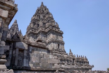 View of ancient hindu Prambanan Temple complex with sunny clear blue sky background. No people.