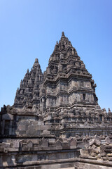 View of ancient hindu Prambanan Temple complex with sunny clear blue sky background. No people.